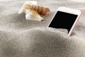 Mobile phone in sand on a beach