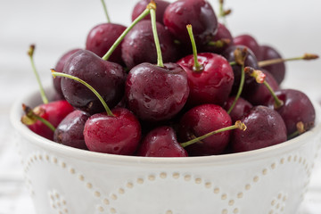 red cherries in a beautiful plate. light background