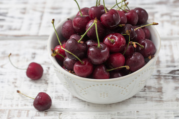 red cherries in a beautiful plate. light background