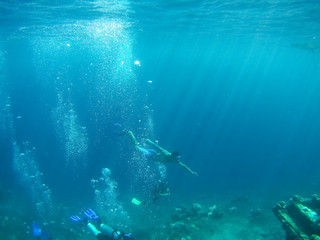 Underwater shot of the woman moving on the breath hold in the depth. Amed village, Bali, Indonesia