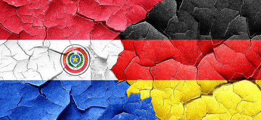 Paraguay flag with Germany flag on a grunge cracked wall