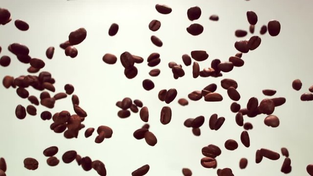 Coffee beans are flying in the air on a white background