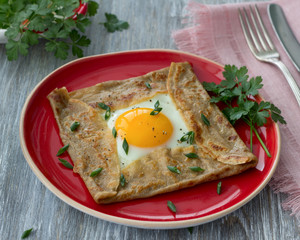 Homemade buckwheat pancakes with egg and cheese on the wooden table, selective focus