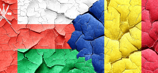 Oman flag with Romania flag on a grunge cracked wall