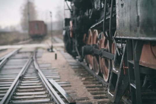 Fototapeta Vintage steam train and the track at the railway station on a cl