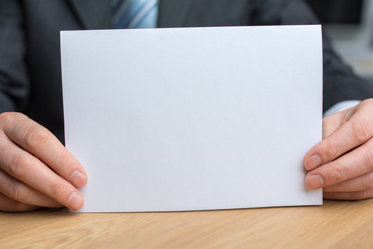businessman holding white blank paper