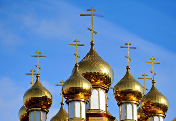 Fototapeta na wymiar Church domes with crosses on a background of blue sky Russia Belgorod