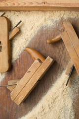 Carpenter tools on wooden table with sawdust.