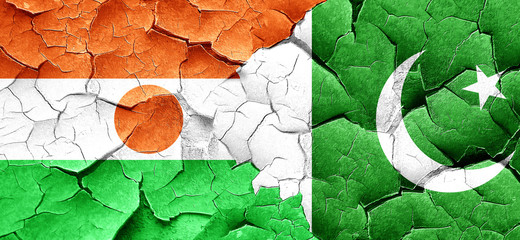 niger flag with Pakistan flag on a grunge cracked wall