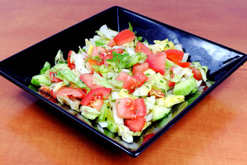 Vegetable salad on a black plate