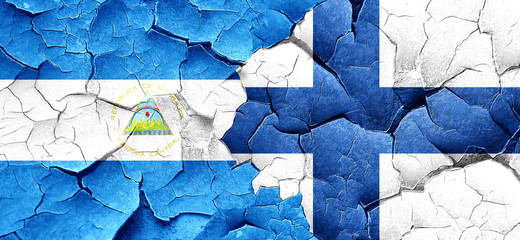 nicaragua flag with Finland flag on a grunge cracked wall