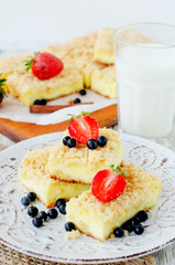 
rustic grated cheese cake with berries , with strawberries , blueberries and milk on a wooden background