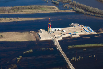 Oil rig in flooded area near great river, top view