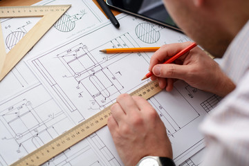 Mechanical engineer at work. Technical drawings. Paper with technical drawings and diagrams.