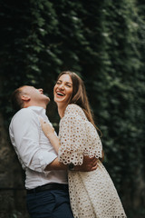 Naklejka premium Young cute couple honeymoon posing in the street holding their hands on dating in a beautiful place italy near ocean and mountains, hug, smile and talk to each other 