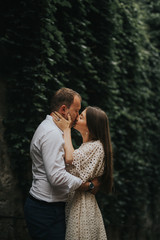 Fototapeta premium Young cute couple honeymoon posing in the street holding their hands on dating in a beautiful place italy near ocean and mountains, hug, smile and talk to each other 