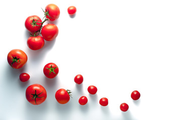 Tomatoes on a branch and cherry on a white background