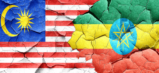 Malaysia flag with Ethiopia flag on a grunge cracked wall