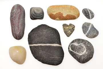 Various pebbles include the heart shape on withe background.