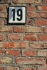 Fototapeta na wymiar Number 19 on a brick wall