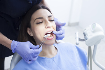 Beautiful woman patient having dental treatment at dentist's office. Woman visiting her dentist