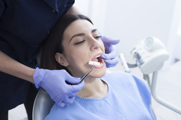 Beautiful woman patient having dental treatment at dentist's office. Woman visiting her dentist