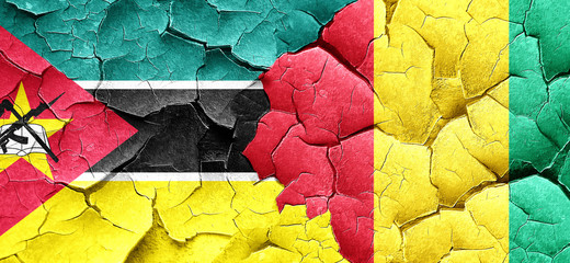 Mozambique flag with Guinea flag on a grunge cracked wall