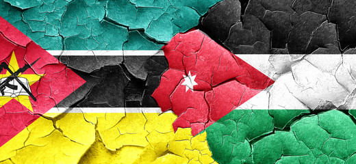 Mozambique flag with Jordan flag on a grunge cracked wall