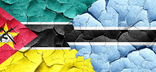 Mozambique flag with Botswana flag on a grunge cracked wall
