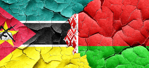 Mozambique flag with Belarus flag on a grunge cracked wall
