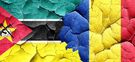 Mozambique flag with Romania flag on a grunge cracked wall