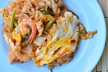 stir fried large noodle seafood and egg with sukiyaki sauce on dish