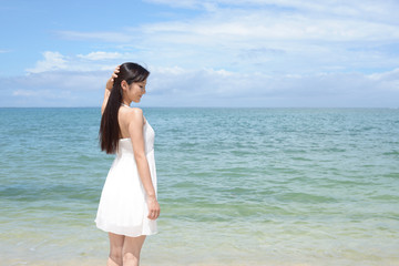 Fototapeta na wymiar 南国沖縄の美しいビーチで寛ぐ女性 