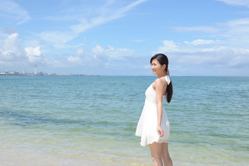 Fototapeta na wymiar 南国沖縄の美しいビーチで寛ぐ女性 