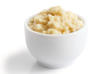 Horseradish sauce in small white bowl in perspective on white.