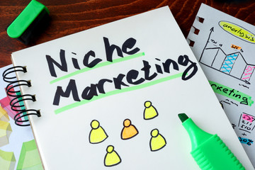 Notepad with sign niche marketing on a wooden background.