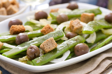 salad green beans with olives and croutins on dish