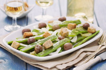vegetable salad with olives and croutins on white dish