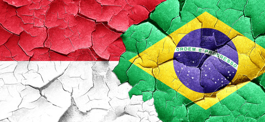 monaco flag with Brazil flag on a grunge cracked wall