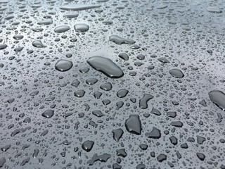 Detail of water drops on a black car after the rain