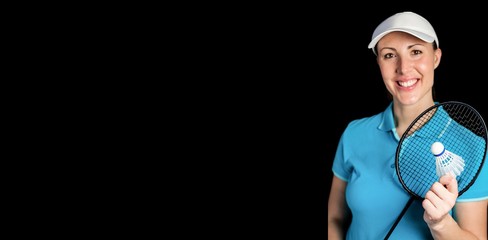 Happy badminton player holding badminton racket and shuttlecock on black background