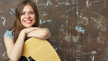 Young woman sitting with guitar.