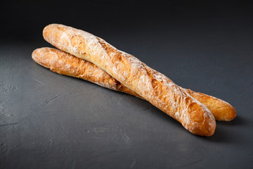 Close-up photo of two french baguettes on gray textural backgrou
