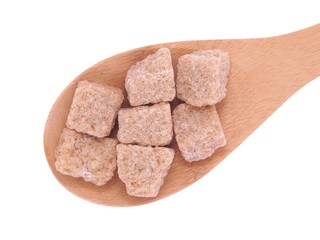 Brown cane sugar unrefined in wooden spoon
