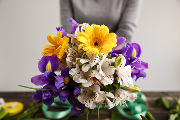 Girl hang bouquet in hands. Focus on flowers.