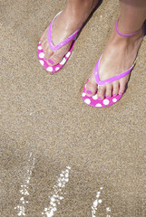 Fototapeta na wymiar Summer, flip flop on feet, beach