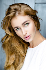 Portrait of young beautiful woman. Long, light, wavy hair and makeup