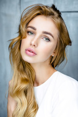 Portrait of young beautiful woman. Long, light, wavy hair and makeup