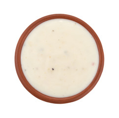 Small bowl of Italian salad dressing isolated on a white background top view.