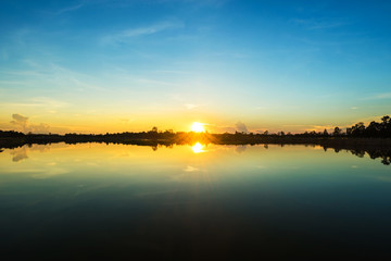 Fototapeta na wymiar Sunset landscape with blue sky at the calm lake